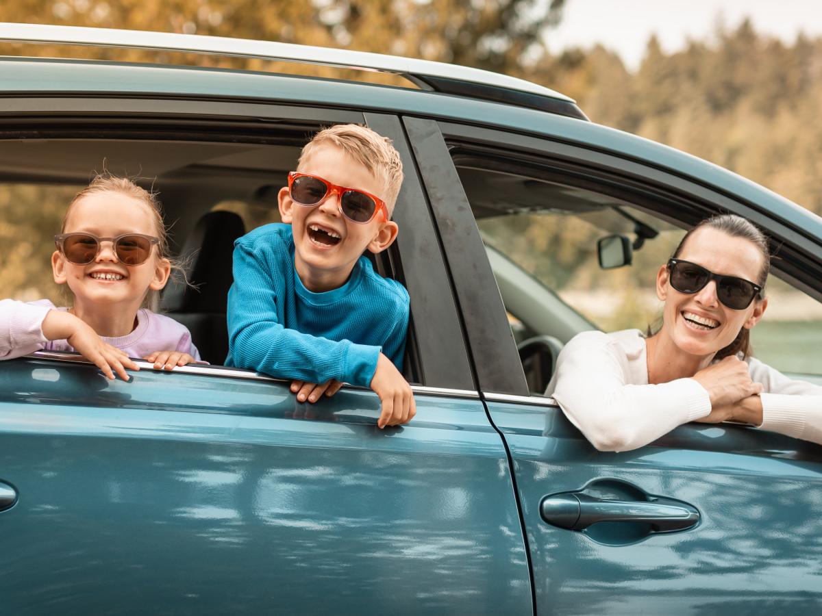 portrait-of-a-smiling-family-inside-car